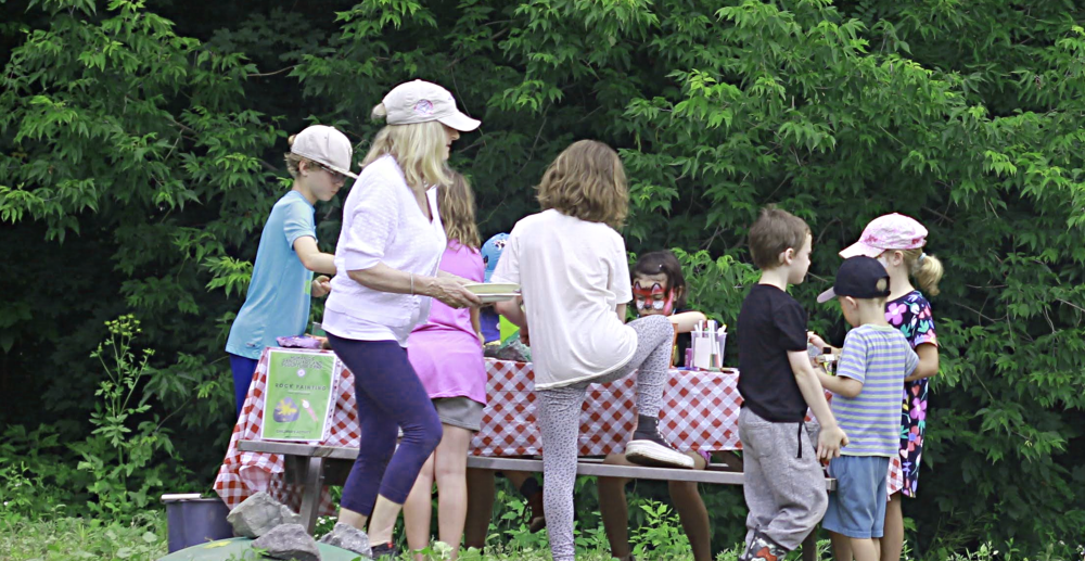 host-birthday-parties kids playing with face paint around a table in a birthday party like setting
